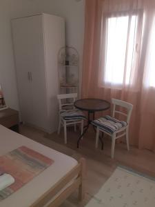 a room with a table and two chairs and a table at Apartman Almira in Donji Štoj