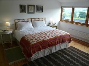 a bedroom with a large bed and a window at Willow Cottage in Presteigne