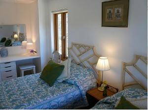 a bedroom with a bed and a desk and a mirror at Willow Cottage in Presteigne