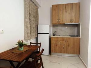 a kitchen with a wooden table and a white refrigerator at Elena Apartments in Keramoti +13 photos