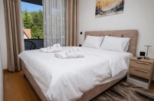 a bedroom with a large white bed with a window at Hedonist Wellness & Spa in Zlatibor +55 photos