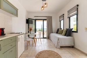 a kitchen and living room with a bed and a table at Helen's 11 boutique in Achladies