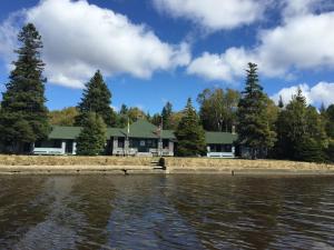 a house on the shore of a body of water at Wishart Point Lodge in Neguac