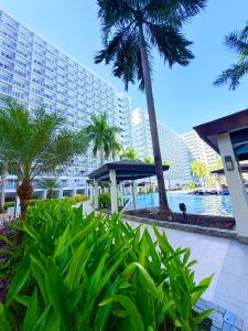 a view of a resort with palm trees and a building at Shell Residences Staycation MOA & NAIA by Keith in Manila