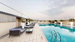 a hotel pool with lounge chairs at Svelte Delhi, a member of Radisson Individuals in New Delhi