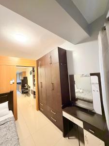 a bedroom with a bed and a desk with a mirror at Shell Residences Staycation MOA & NAIA by Keith in Manila