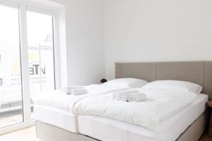 two white beds in a room with a window at Kajüte in Böhl
