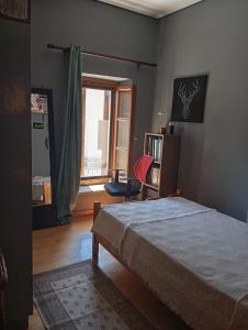 a bedroom with a bed and a chair and a window at Deli House in Promírion