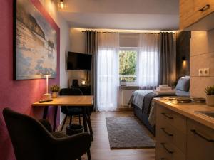 a bedroom with a bed and a desk and a table at Bellevue Residence l City Balkon in Koblenz