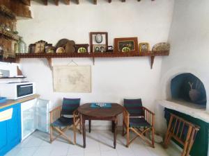 a kitchen with a table and chairs and a counter at Kastro Astypalea Spitaki in Astypalaia