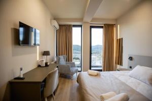 a hotel room with a bed and a desk and chairs at AUTOGRAPH Kutaisi in Kutaisi