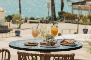 a plate of food and two drinks on a table at Vale Do Lobo Resort in Vale do Lobo