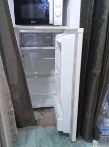 an open refrigerator with a microwave on top of it at Résidence cosy in Abidjan