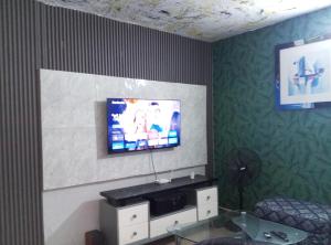 a living room with a tv on a wall at Résidence cosy in Abidjan +16 photos