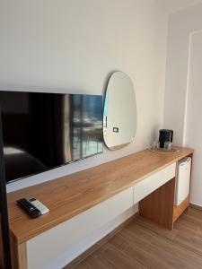 a room with a flat screen tv and a mirror at Filikuri Boutique Hotel in Himare