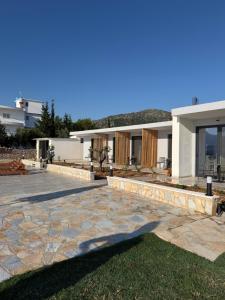 a house with a stone patio in front of it at Filikuri Boutique Hotel in Himare