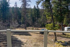 a white fence with a view of a forest at Off Grid Retreat Stay for 7 in Rexford