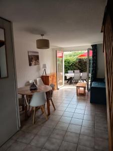 a kitchen and living room with a table and chairs at Au refuge de Rolf in Calvisson