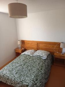 a bedroom with a bed with a black and white comforter at Au refuge de Rolf in Calvisson +35 photos