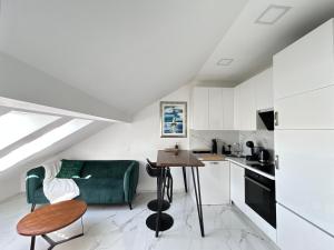 a kitchen and a living room with a green couch at New apartman Summer in Kaštela