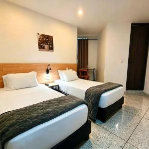 a hotel room with two beds and a table at Bianco Hotel Boutique in Cúcuta