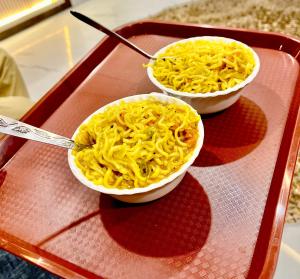 two bowls of macaroni and cheese on a tray at Shiv Dham Palace in Varanasi