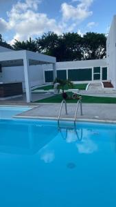 a blue swimming pool with a palm tree in it at Comoda y hermosa casa MINDY in Tuxpan de Rodríguez Cano
