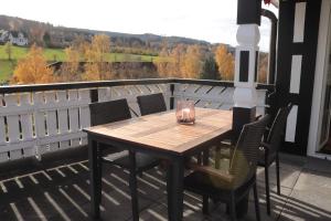 a wooden table and chairs on a balcony at Rübenkämpers Ferienwohnungen in Schmallenberg
