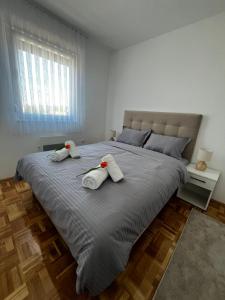 a bedroom with a large bed with towels on it at City Nest, Free Parking & City Center in Prijedor