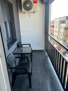 a balcony with two chairs and a table and a fan at City Nest, Free Parking & City Center in Prijedor