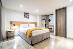 a bedroom with a large bed and a table at Bianco Hotel Boutique in Cúcuta
