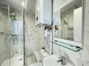 a white bathroom with a sink and a shower at Hôtel My Suite Paris in Paris