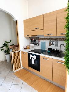 a kitchen with wooden cabinets and a stove top oven at Domus REA Bracciano - Self Check-in H24 in Bracciano