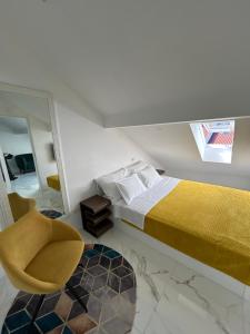 a bedroom with a bed and a chair and a mirror at New apartman Summer in Kaštela