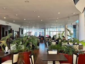 a restaurant with tables and plants in a building at Palmar Hotel Casino in Concordia
