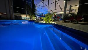 a swimming pool with blue lighting in a building at Palmar Hotel Casino in Concordia