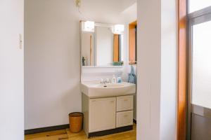 a bathroom with a sink and a mirror at 温泉街近くの一棟貸し ひだまり in Kirishima +41 photos