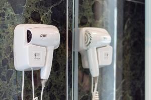 two hair dryers are hanging on a wall at D&D HOTEL Ksamil in Ksamil
