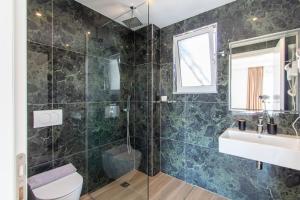 a bathroom with a shower and a sink and a toilet at D&D HOTEL Ksamil in Ksamil