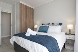 a bedroom with a large white bed with blue accents at Ballito Hills 478 in Ballito
