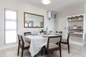 a dining room with a table with chairs and a mirror at Ballito Hills 478 in Ballito +18 photos
