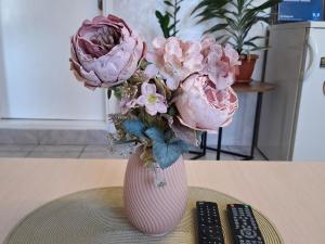 a pink vase with pink flowers sitting on a table at Guesthouse Jelena in Višegrad