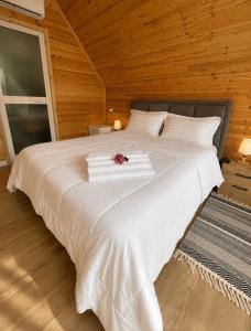 a large white bed with a bouquet of flowers on it at Guest house Panorama in Koman