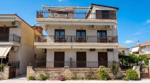 a tall white building with balconies on a street at Anthoula House Sarti in Sarti