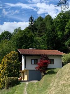a small house on a grassy hill at Ferienhaus Erika in Telfs