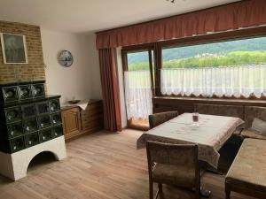 a living room with a table and a large window at Ferienhaus Erika in Telfs
