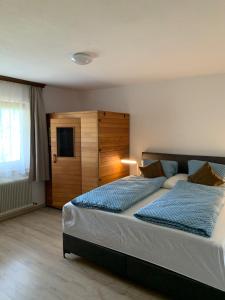 a bedroom with a large bed with a wooden headboard at Ferienhaus Erika in Telfs