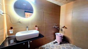 a bathroom with a sink and a mirror and a toilet at Whispering Woods in Gorthan