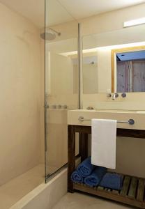 ein Badezimmer mit Dusche, Waschbecken und Spiegel in der Unterkunft Oceano Patagonia in Puerto Pirámides