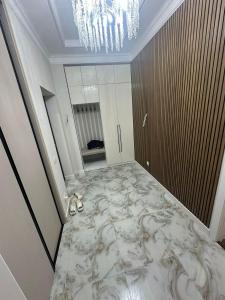 a room with a marble floor with a chandelier at Бахт in Bishkek